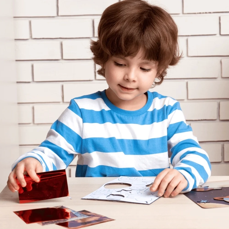 Chłopiec pracuje nad projektem kosmicznym z folią z zestawu Skillmatics Foil Fun.