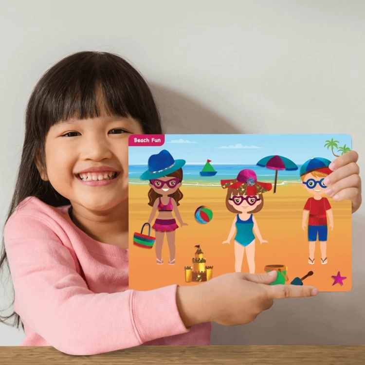 Dziewczynka z uśmiechem prezentuje ozdobiony folią obrazek Beach Fun.