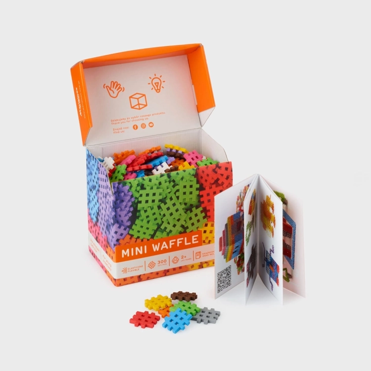 Otwarte pudełko klocków Marioinex Mini Waffle, widoczna instrukcja i kolorowe elementy.