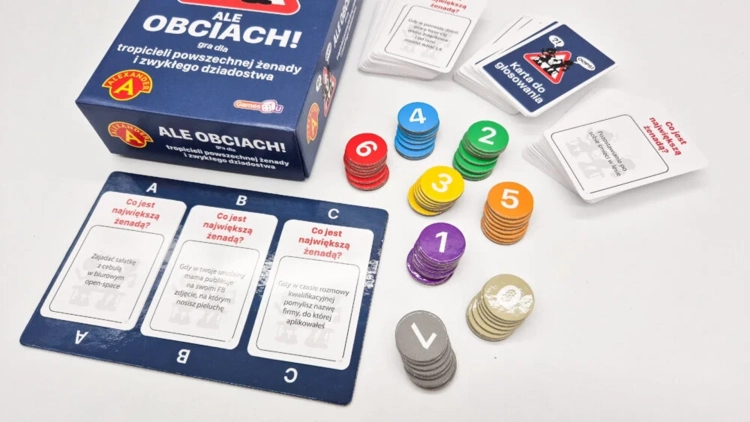 Gra karciana Ale Obciach! Alexander, widok z góry na elementy gry: karty pytań, żetony i pudełko.