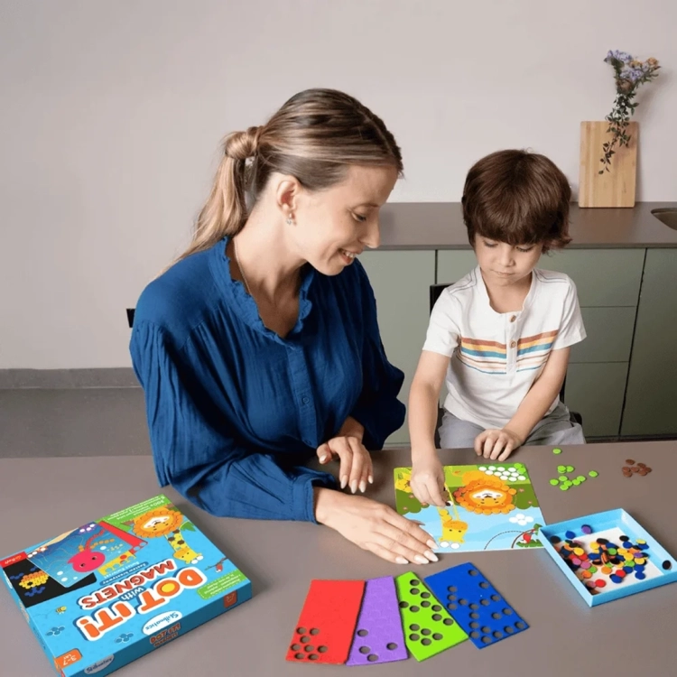 Mama i syn bawią się Skillmatics Dot it! With Magnets, układając magnetyczne kółka na planszy z lwem, ćwiczenie kreatywności i skupienia.
