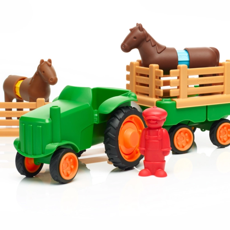 Elementy zestawu SmartMax My First Tractor: zielony traktor, czerwona figurka rolnika, przyczepa z płotkiem i dwa magnetyczne koniki.