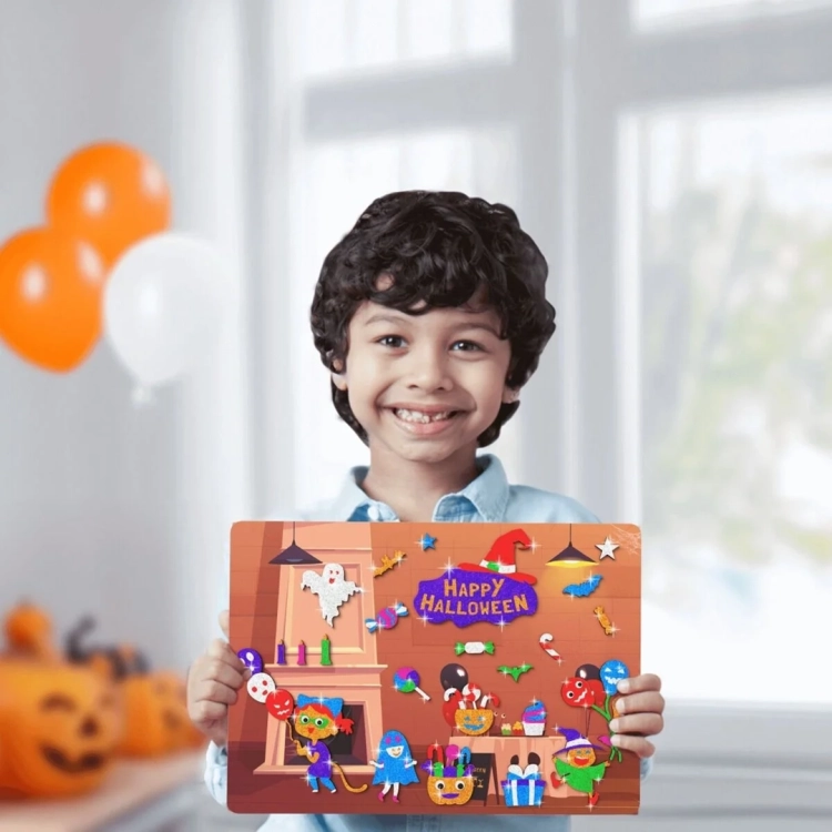 Uśmiechnięty chłopiec trzyma gotową, własnoręcznie ozdobioną planszę przedstawiającą wnętrze domu z kominkiem i postaciami w klimacie Halloween.