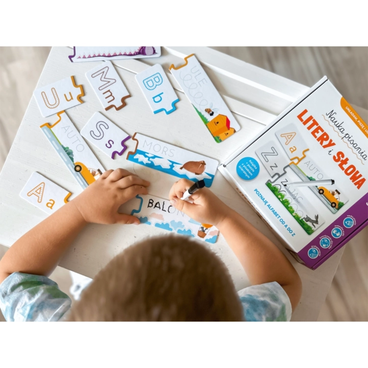 Widok z góry na dziecko układające i uzupełniające kolorowe puzzle z literami oraz obrazkami takimi jak auto, mors i balon.