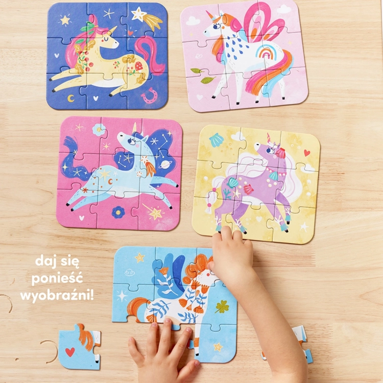 Pięć kolorowych układanek z jednorożcami leży na drewnianym blacie, a dziecięce dłonie dopasowują elementy jednej z nich.