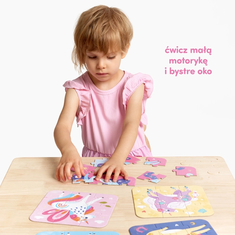 Dziewczynka w różowej bluzce siedzi przy stole i z koncentracją układa puzzle z baśniowymi postaciami.