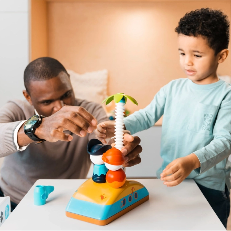 Dorosły i dziecko wspólnie bawią się zestawem magnetycznym piratów, dopasowując biały, prążkowany element do zabawki.