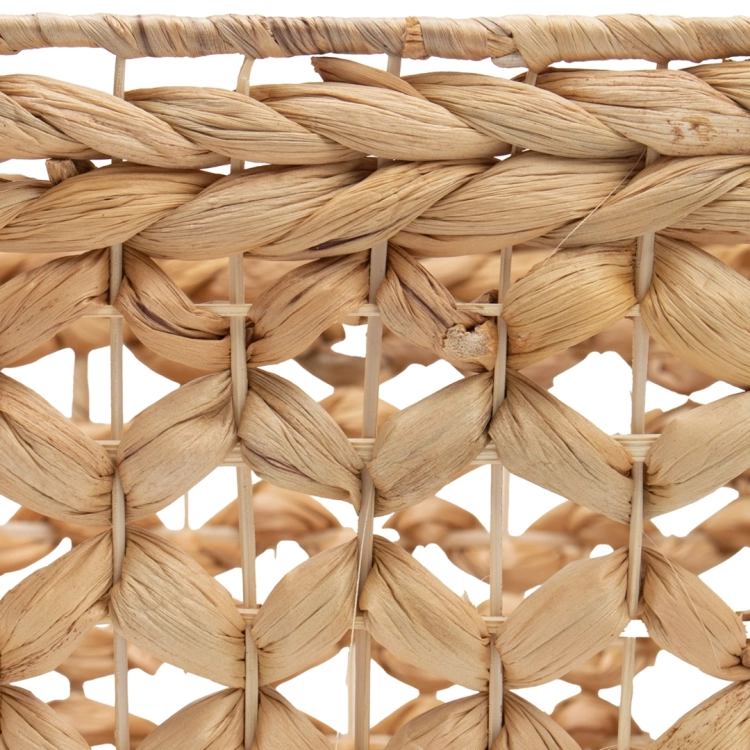 Detal struktury plecionego kosza z hiacyntu wodnego. Zdjęcie pokazuje gęsty, ażurowy splot o naturalnym, jasnobrązowym odcieniu, charakterystyczny dla dodatków w stylu boho.