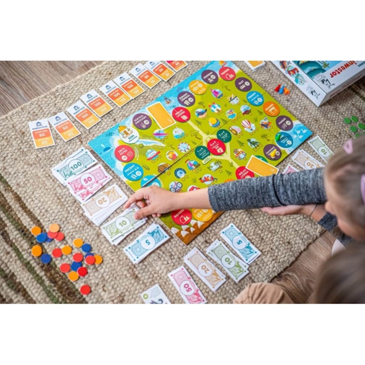 Zbliżenie na dłonie graczy układających banknoty o różnych nominałach obok planszy podczas rozgrywki w grę ekonomiczną.