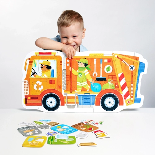 Chłopiec siedzi za dużą, ułożoną śmieciarką z puzzli; przed nim leżą drobne elementy przedstawiające różne rodzaje odpadów do segregacji.