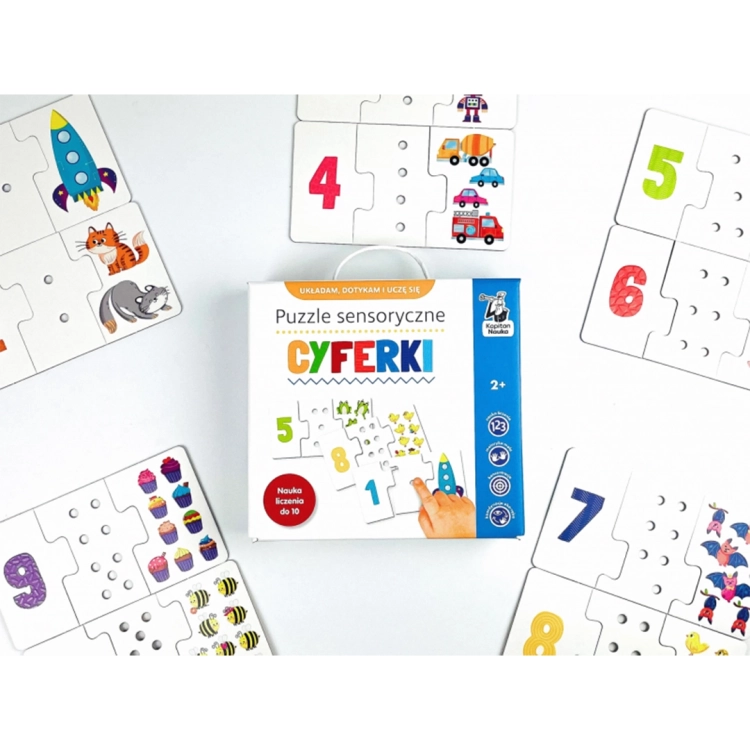 Pudełko puzzli sensorycznych Kapitan Nauka otoczone ułożonymi zestawami z rakietą, kotkami, robotami i żabkami.