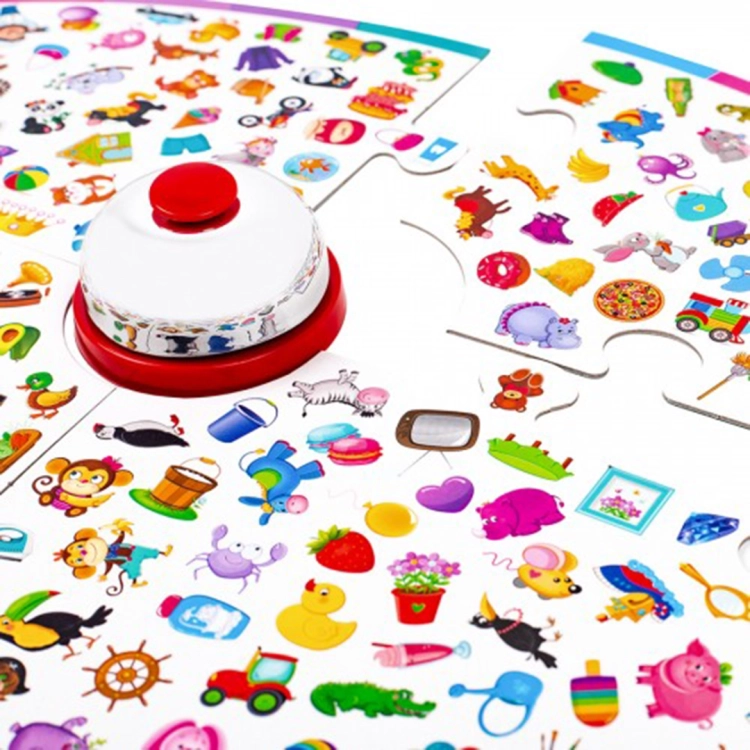 Detal gry: biały dzwonek recepcyjny na czerwonej podstawie ustawiony na planszy pełnej drobnych, kolorowych ilustracji dla dzieci.