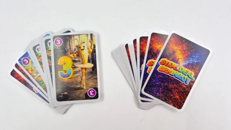 Dwa stosy kart rozłożone w wachlarz na białym tle. Jeden stos pokazuje ilustracje z postaciami i cyframi, drugi kolorowe rewersy kart.