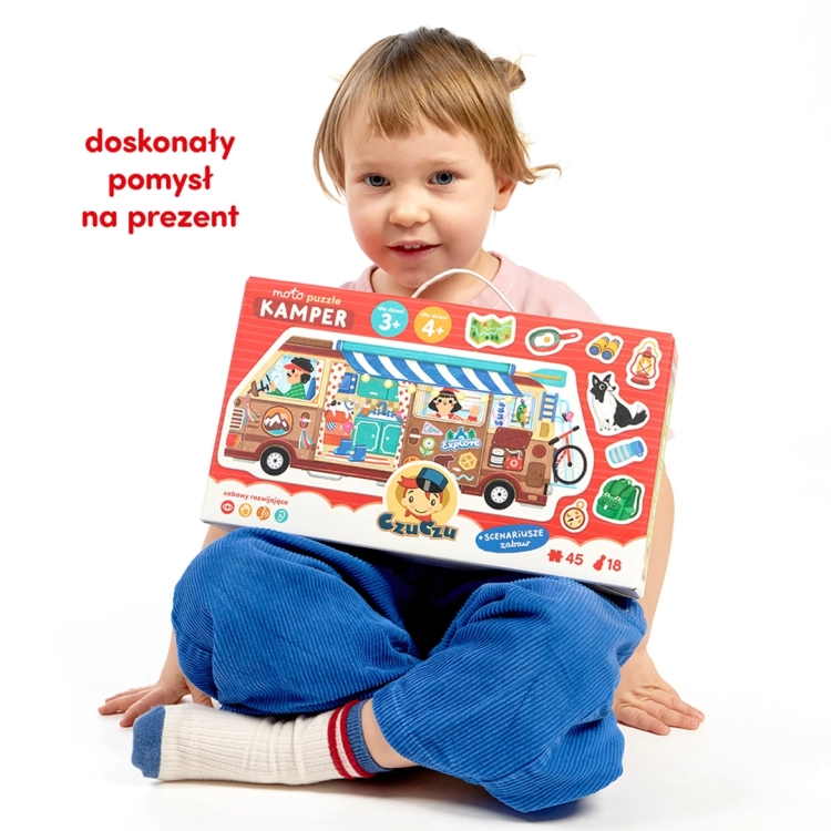 Dziecko siedzi na podłodze i trzyma duże, kolorowe pudełko puzzli CzuCzu Moto Puzzle Kamper. Napis: „doskonały pomysł na prezent”.
