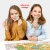 Dwie uśmiechnięte dziewczynki prezentują do kamery pojedyncze elementy puzzli na tle rozłożonej układanki Mapa Polski.