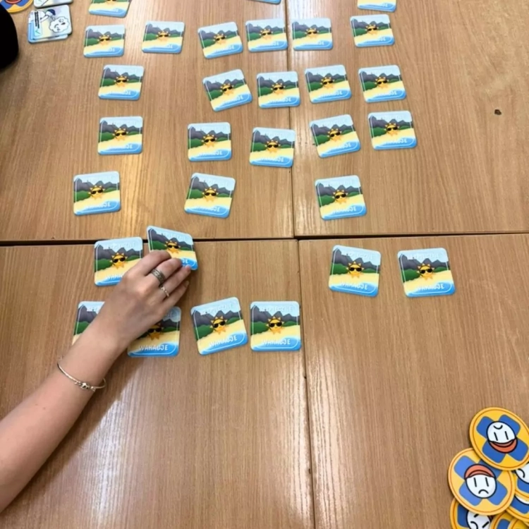 Dziecko grające w grę stolikową Bezpieczne wakacje beGame, układanie kafelków na stole.
