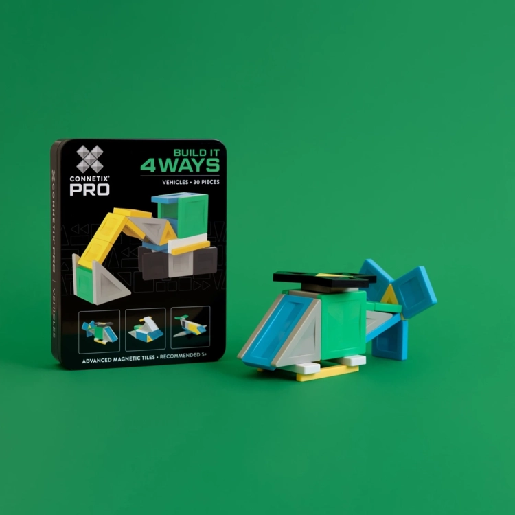 Śmigłowiec ułożony z klocków magnetycznych Connetix PRO stojący obok pudełka zestawu na zielonym tle.