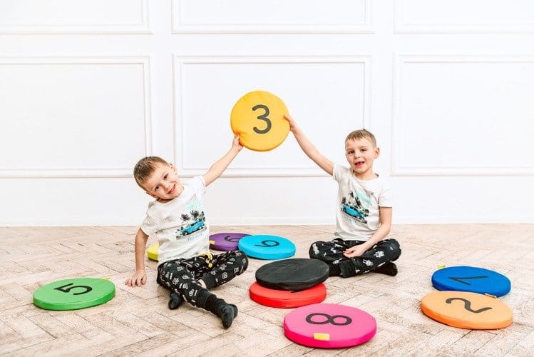 dzieci bawią się na poduszkach do siedzenia na podłodze