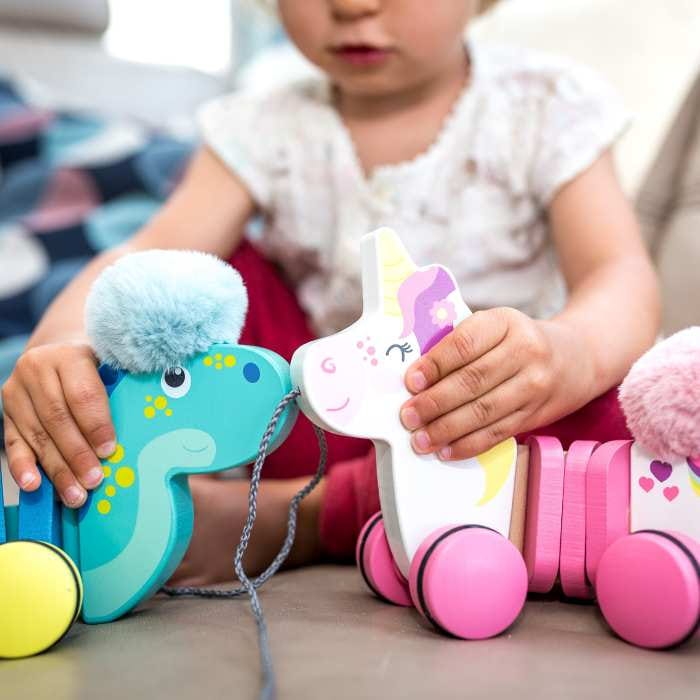 dziecko bawiące się zabawką do ciągnięcia z drewna