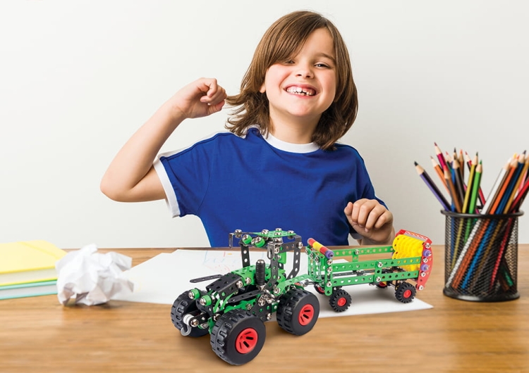 Dziecko montujące traktor Fred – edukacyjna zabawa konstrukcyjna.