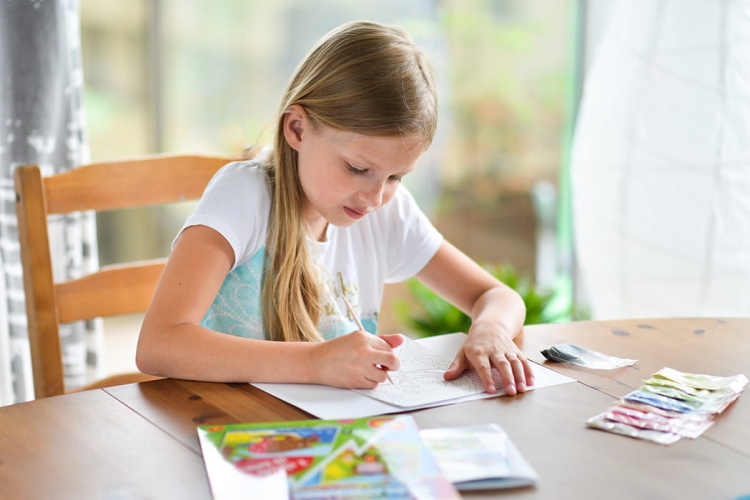 Dziecko bawi się Piaskowymi Malowankami Sandy – rozwój zdolności manualnych.