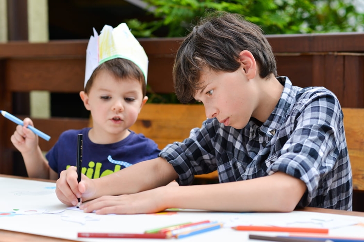 Dziecko rysuje dinozaura przy pomocy szablonu Alexander.