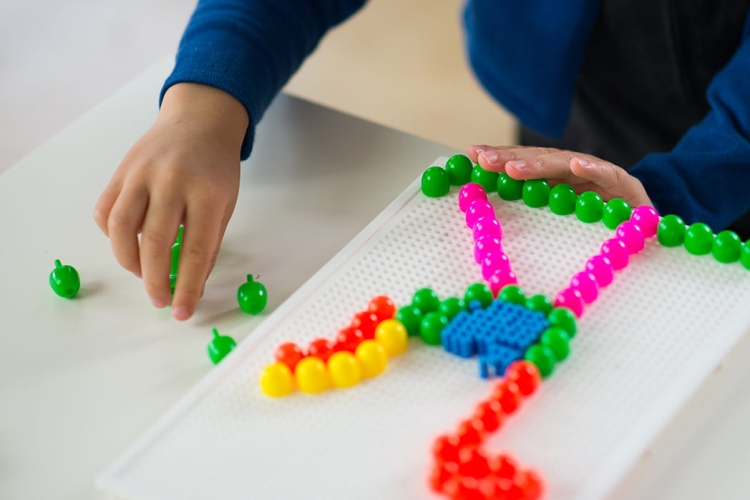 Dziecko układające wzory w Magicznych Mozaikach 80 – kreatywna zabawa edukacyjna.