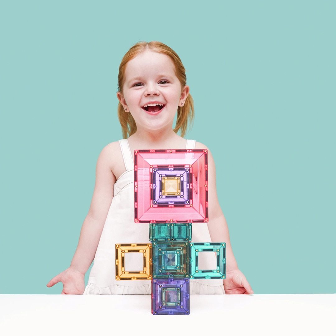 Dziewczynka prezentująca budowlę z klocków magnetycznych Connetix Pastel Portal Pack