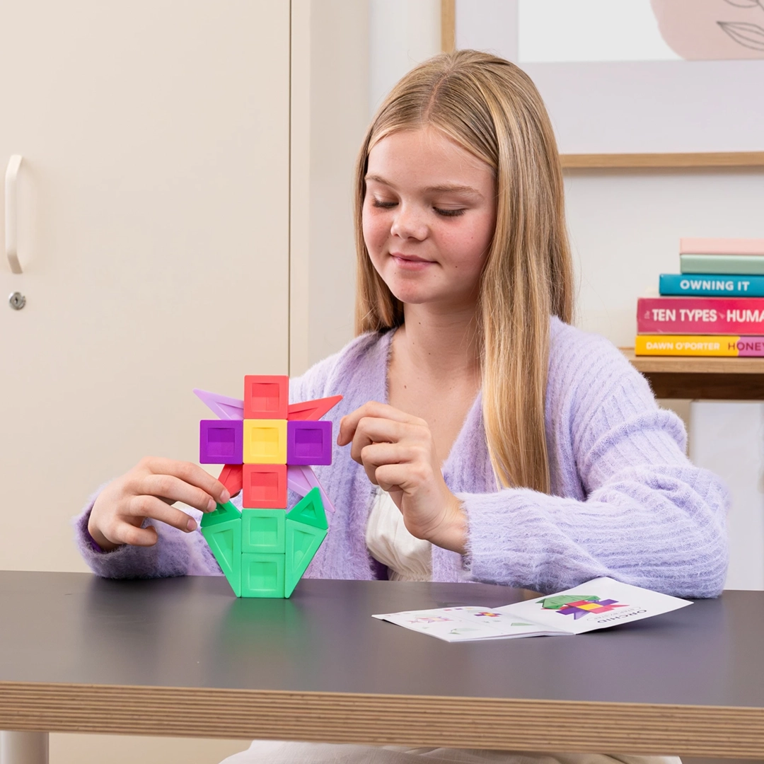 Dziewczynka układa wzór kwiatka z zestawu klocków magnetycznych Connetix PRO Build It 4 Ways Flowers Pack