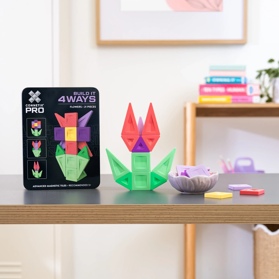 Klocki magnetyczne Connetix PRO Build It 4 Ways Flowers Pack ułożone w kwiat obok czarnego pudełka